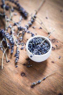 Lavanta çiçekleri fışkın ahşap arka plan üzerinde küçük kase