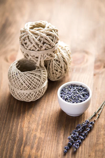 Flores de lavanda com carretel de linha em um fundo de madeira — Fotografia de Stock