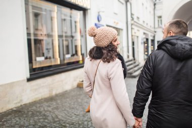 Genç çift, elini tutarak şehirde yürümek