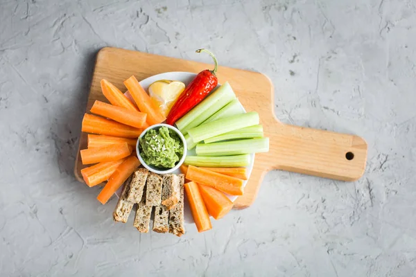 Vegan nyttiga snacks: guacamole, morötter, selleri — Stockfoto