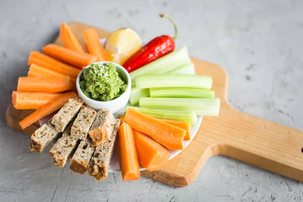 Vegan nyttiga snacks: guacamole, morötter, selleri — Stockfoto