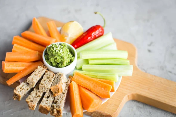 Vegan nyttiga snacks: guacamole, morötter, selleri — Stockfoto