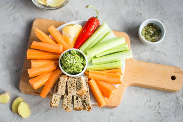 Vegan nyttiga snacks: guacamole, morötter, selleri — Stockfoto