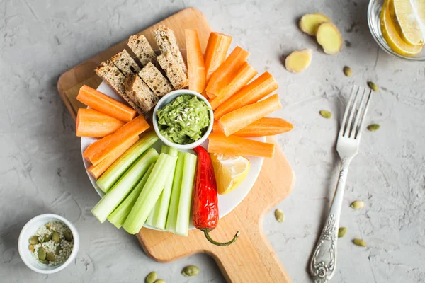 Vegan nyttiga snacks: guacamole, morötter, selleri — Stockfoto