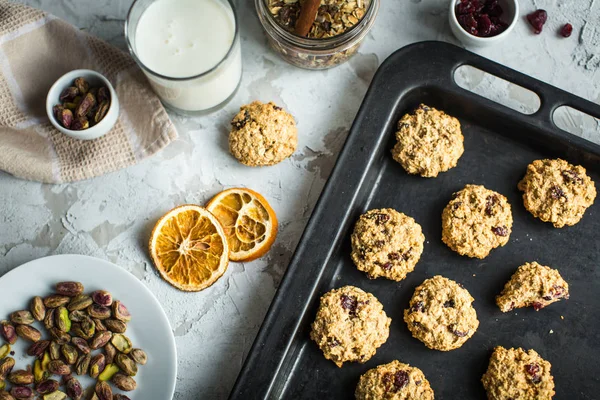 Galletas de avena con arándanos en una bandeja para hornear y leche —  Fotos de Stock