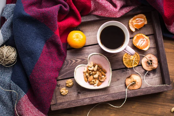 Wooden tray with a cup of coffee, nuts and orange on window — Stock Photo, Image