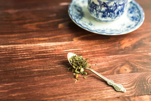 Taza de té sobre fondo de madera y hojas de té —  Fotos de Stock
