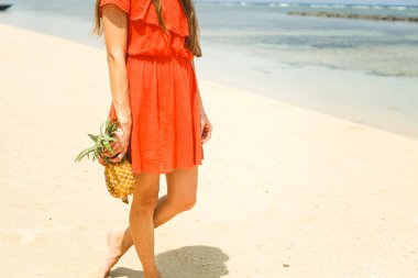 ananas sahilde tutan şapkalı kız