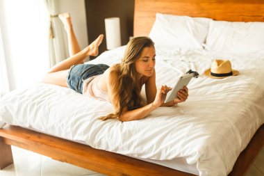 Genç kızla yatakta yatıyordu tablet