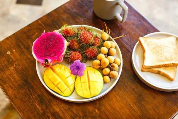 Buah-buahan eksotis di piring: mangga, buah naga; mangga; nanas sebuah — Stok Foto
