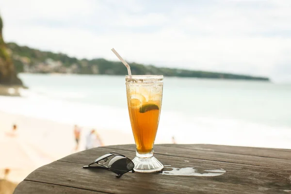 Chá de gelo e copos na mesa de madeira na praia — Fotografia de Stock