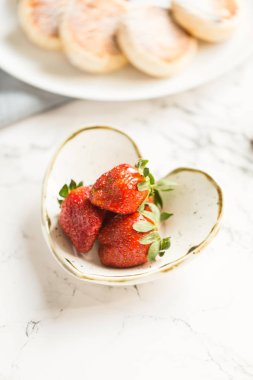 Kalp şeklinde çömlek içinde taze çilek