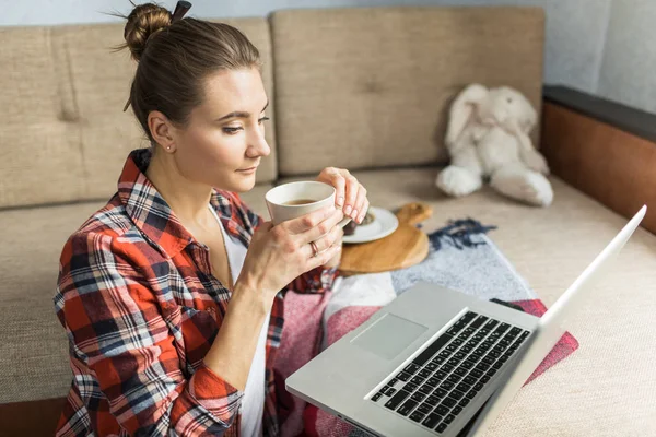 kadın kanepede evde çay içiyor