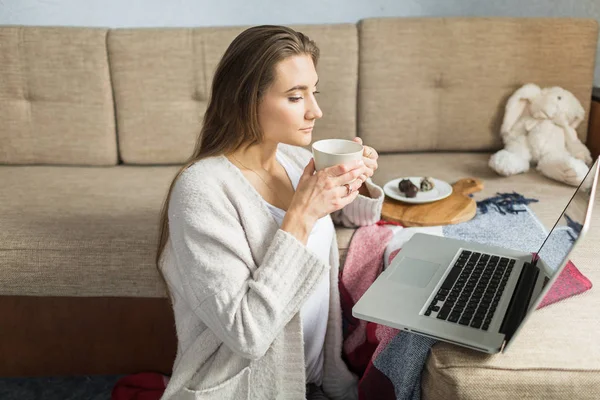 kadın kanepede evde çay içiyor