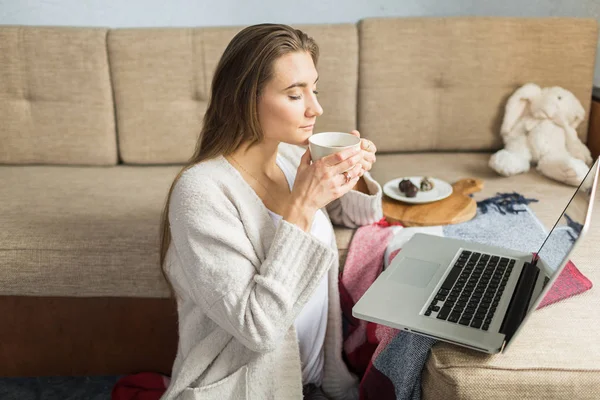 kadın kanepede evde çay içiyor