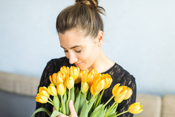 Girl with big bouquets of yellow tulips