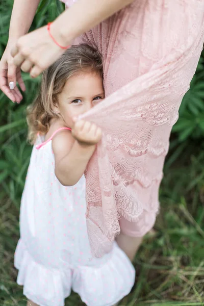 Figlia abbraccia madre, famiglia fotosessione nei fiori — Foto Stock