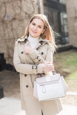 şehirde montlu genç kadın yürüyor