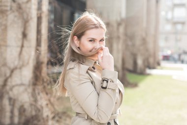 şehirde montlu genç kadın yürüyor