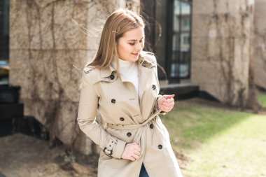 şehirde montlu genç kadın yürüyor