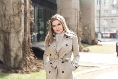 şehirde montlu genç kadın yürüyor