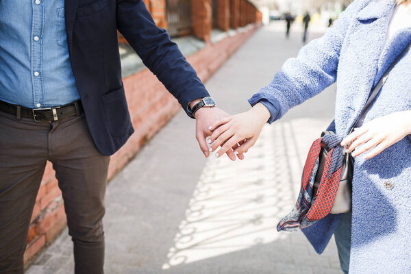 Любящий юноша и девушка держатся за руки
