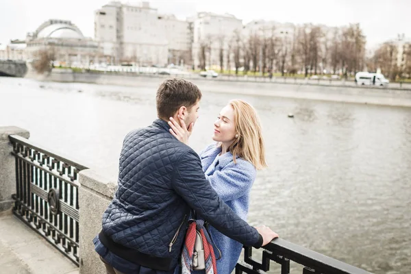 Jeune homme et fille embrasser sur le fond du pont — Photo