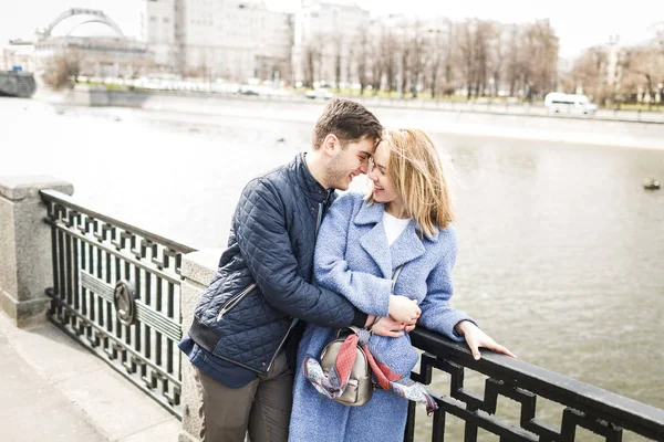 Mladý kluk a dívka objetí na pozadí bridge — Stock fotografie