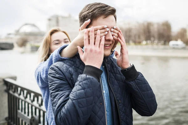 Girl closes her boyfriend's eyes on date — Stock Photo, Image