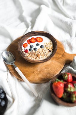Yulaf ezmesi çilek ve beyaz bir levha üzerinde yaban mersini