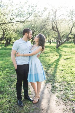 Genç aşık çift parkta yürüyor.