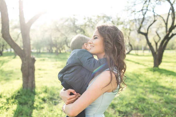 Mamá mantiene al bebé en sus brazos en verano —  Fotos de Stock