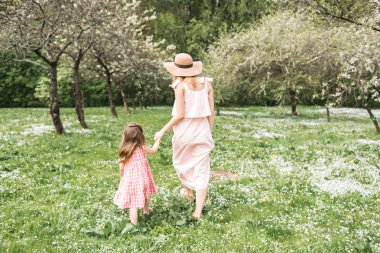 Anne ve kızı bahçede yürüyor
