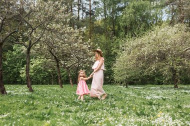 Anne ve kızı bahçede yürüyor