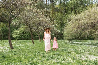 Anne ve kızı bahçede yürüyor