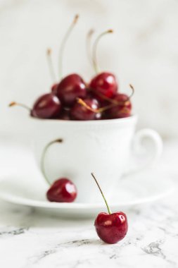 Olgun tatlı kiraz bir beyaz kupa