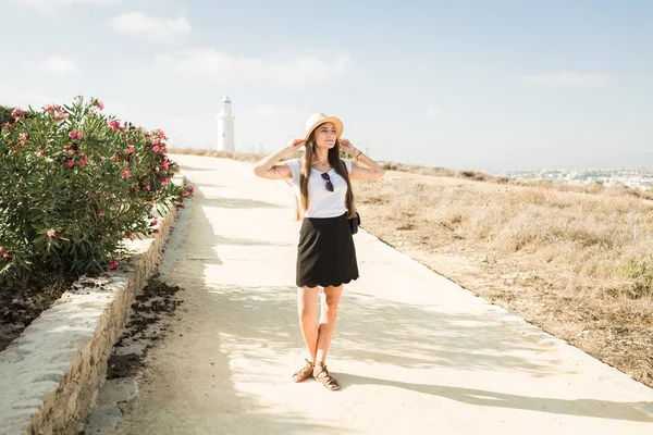Chica en un sombrero de paja sobre un fondo de faro en Chipre — Foto de Stock