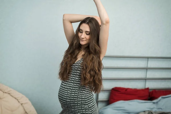 Fată gravidă într-o rochie în dormitor — Fotografie, imagine de stoc