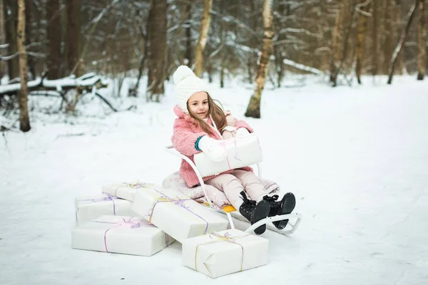 Dívka v sáně s dárky — Stock fotografie