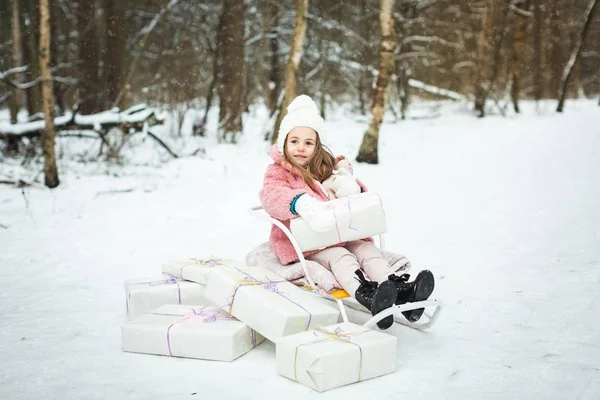 Девушка в санях с подарками — стоковое фото