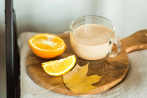 Xícara de alfarroba com laranjas em uma placa de corte — Fotografia de Stock