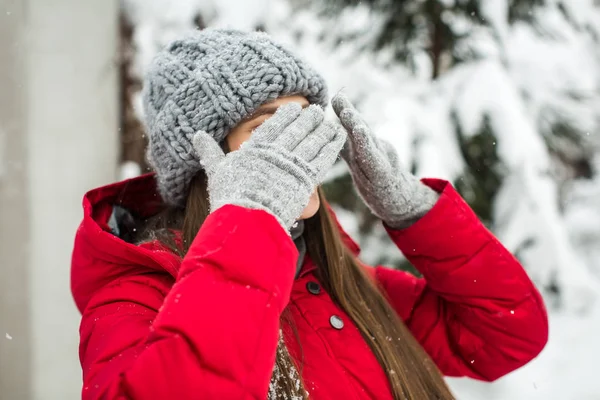 Mladá žena v zimní čepice zavře oči s rukama — Stock fotografie