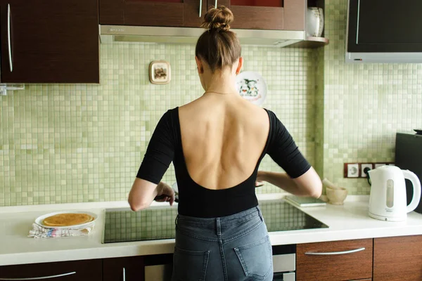 La mujer está cocinando en la cocina, la vista trasera —  Fotos de Stock