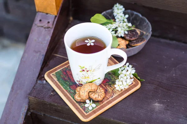 A cup of tea and biscuits on the porch of a wooden house in vill — Stock Photo, Image