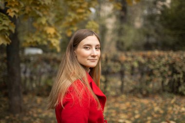 young woman on a walk in the park in autumn in fine weather