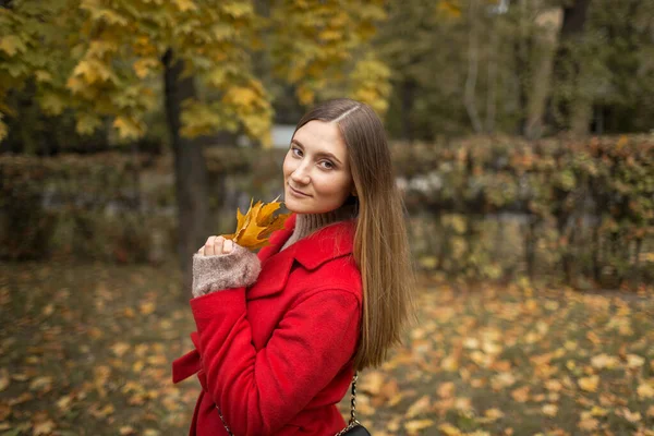 Jonge vrouw op een wandeling in het park in de herfst bij mooi weer — Stockfoto