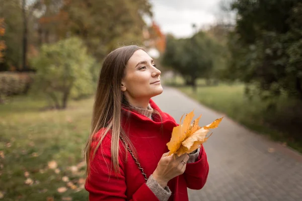 Jeune femme en promenade dans le parc en automne par beau temps — Photo
