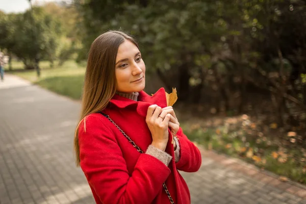 Молодая женщина на прогулке в парке осенью в хорошую погоду — стоковое фото