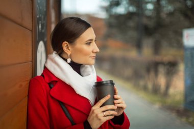 young woman on a walk with cappuccino coffee