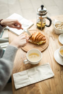 Genç kız kahvaltıda, İngiliz kahvaltısı kruvasanla